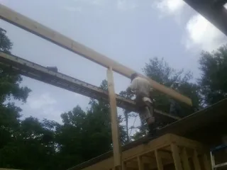 Carpenter setting a ridge beam over a new addition frame — Ice Dam Removal by Roofing Brothers in Ahoskie