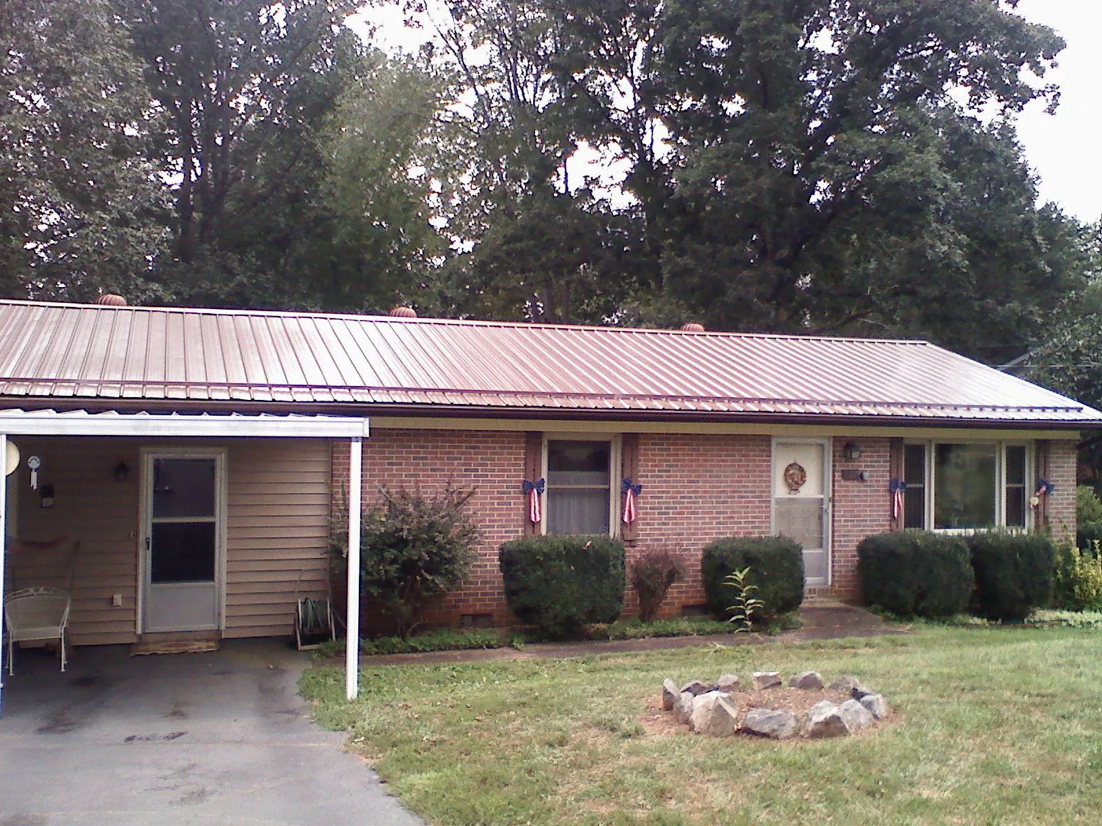 Bronze metal roof and carport on a brick ranch home — Roof Repair work by our crew in Ahoskie
